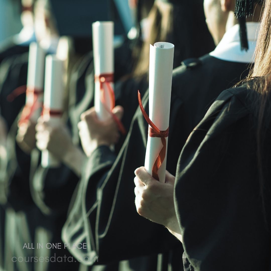 Graduates holding diplomas, celebration attire.