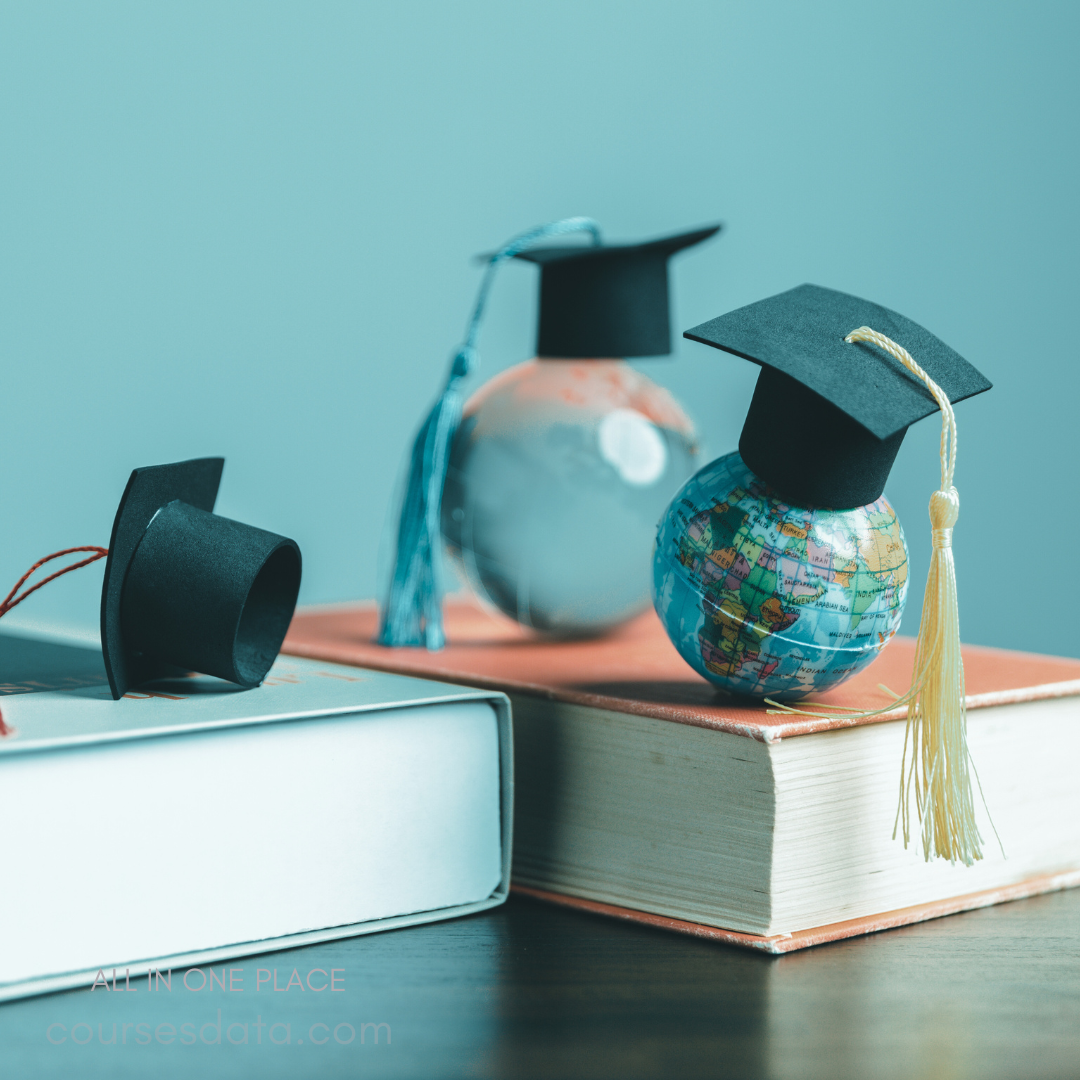Graduation caps on globes. Books are stacked below. Light blue background. Colorful tassels hang down. Educational theme emphasized.