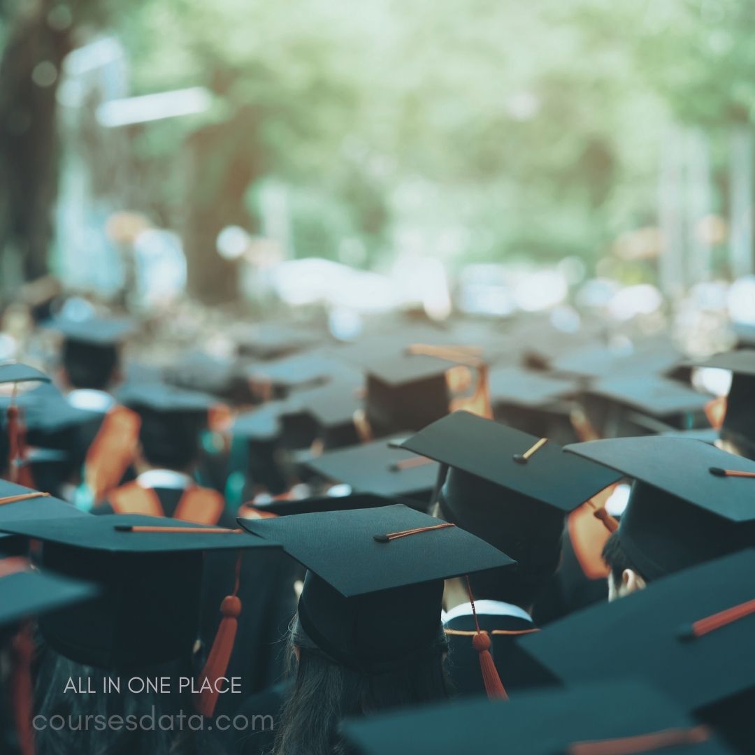 Graduation caps in crowd. Green, blurred background. Ceremony atmosphere, celebration. Black and orange colors. Students ready for graduation.