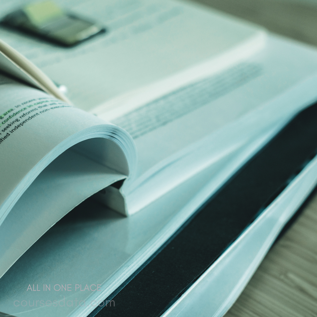 Papers on wooden surface. Curled page edges. Highlighted text visible. Binder clip placed above. Stacked documents in focus.