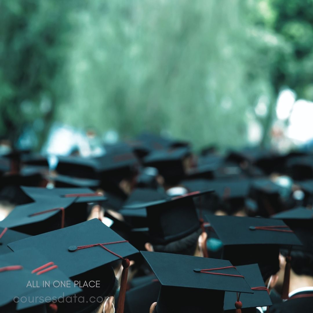 Graduates in black caps. Celebratory outdoor gathering. Blurred background greenery. Focus on caps and tassels. Symbol of achievement and transition.