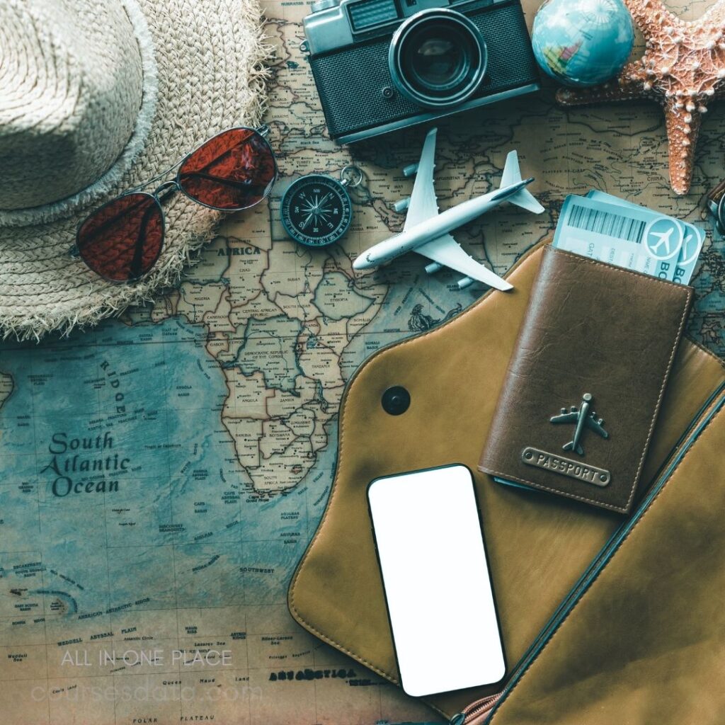 Travel essentials on map. Vintage camera and sunglasses. Compass, toy airplane, passport. Smartphone beside travel documents.