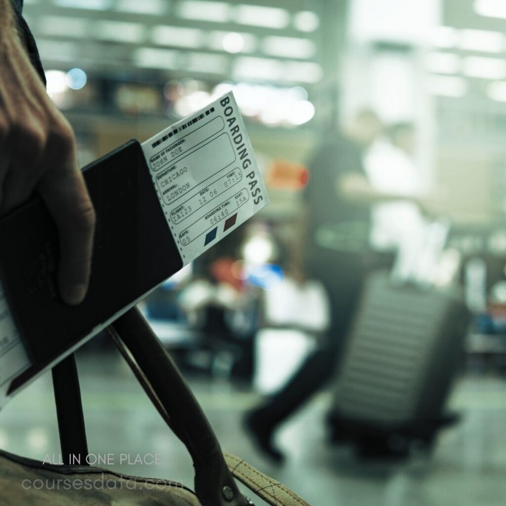 Hand holding passport and boarding pass. Airline ticket details visible. Busy airport background. Luggage in motion. Traveler preparing to board.