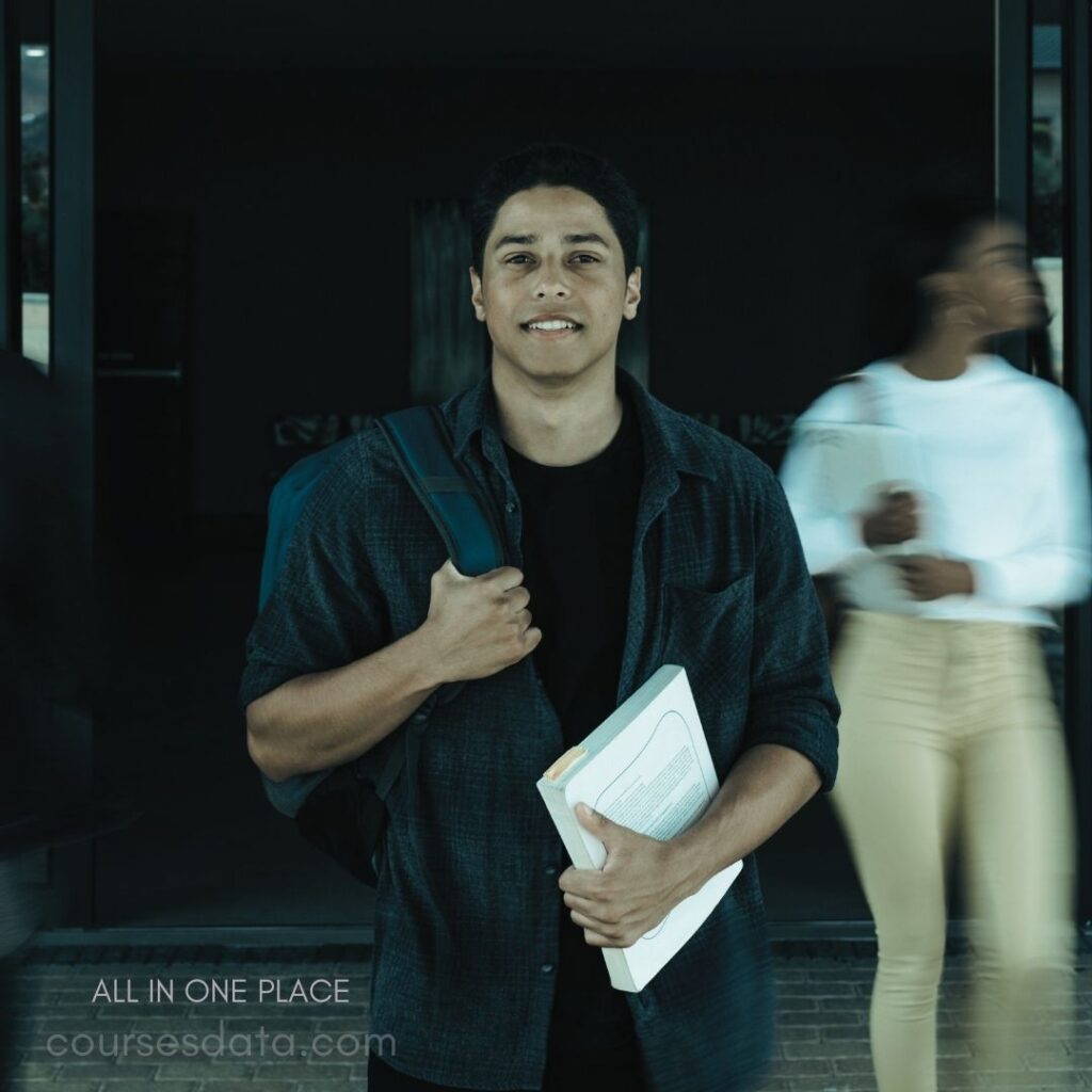 Smiling male student, backpack, books.