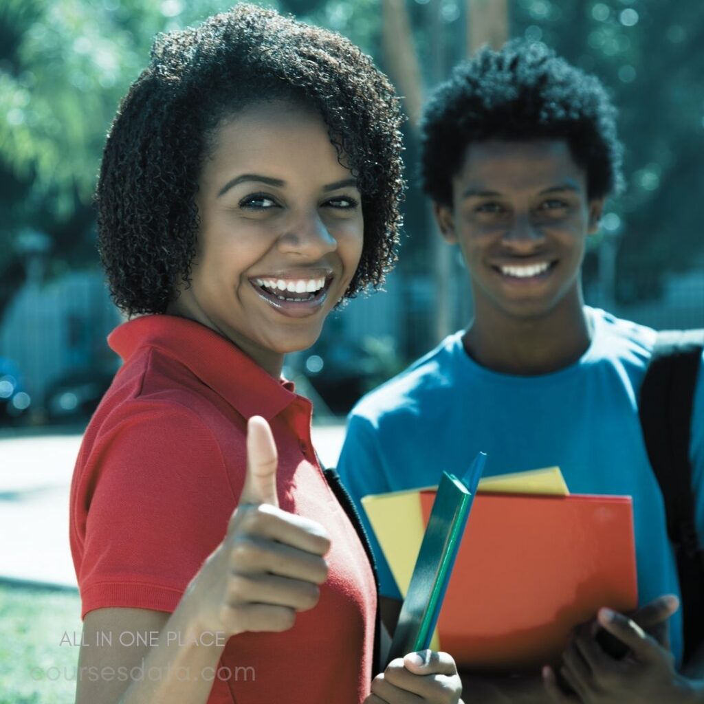 Smiling girl with thumbs up. Boy holds colorful folders. Outdoors, sunny background. Casual attire and friendly vibe.