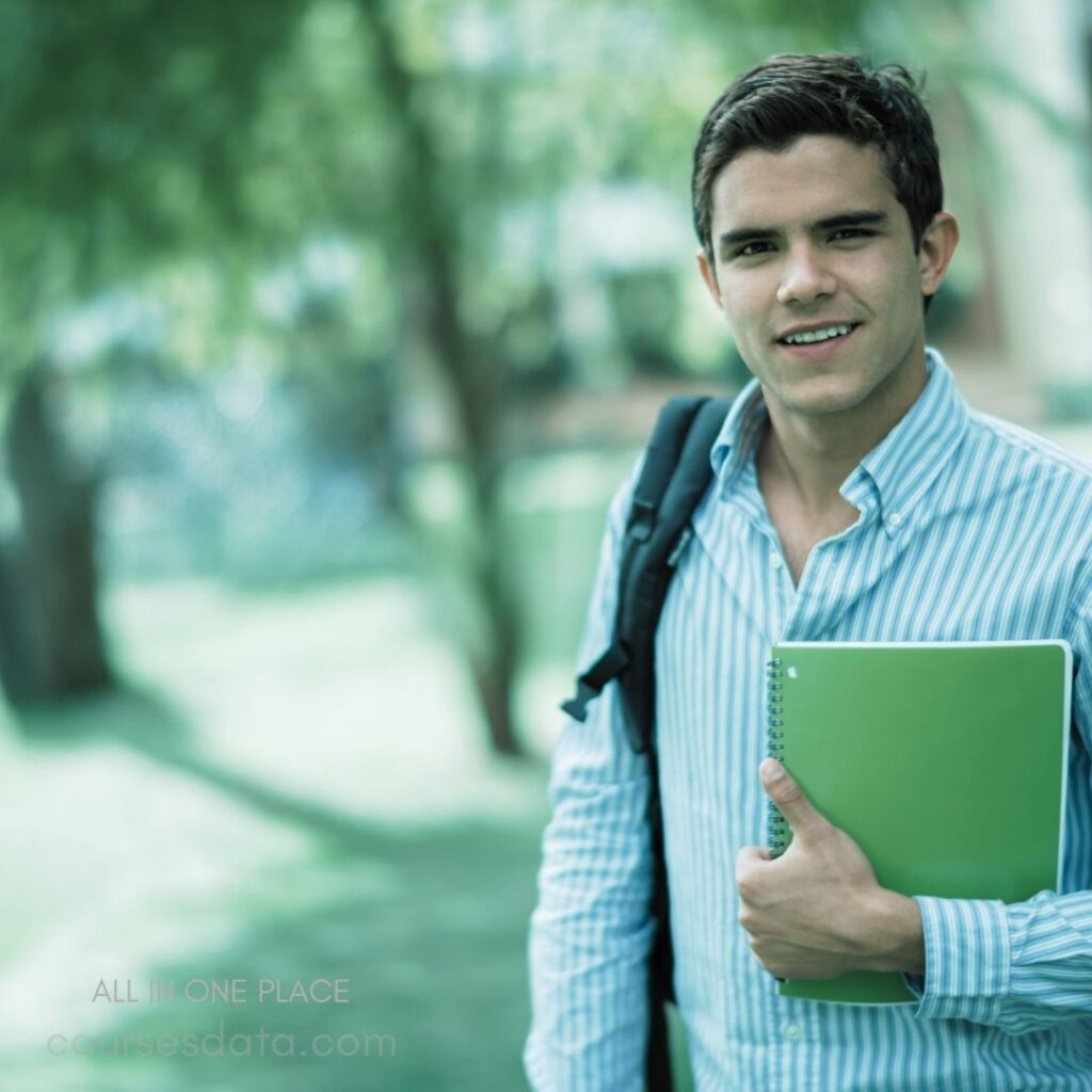 Smiling student holding notebook, outdoors.