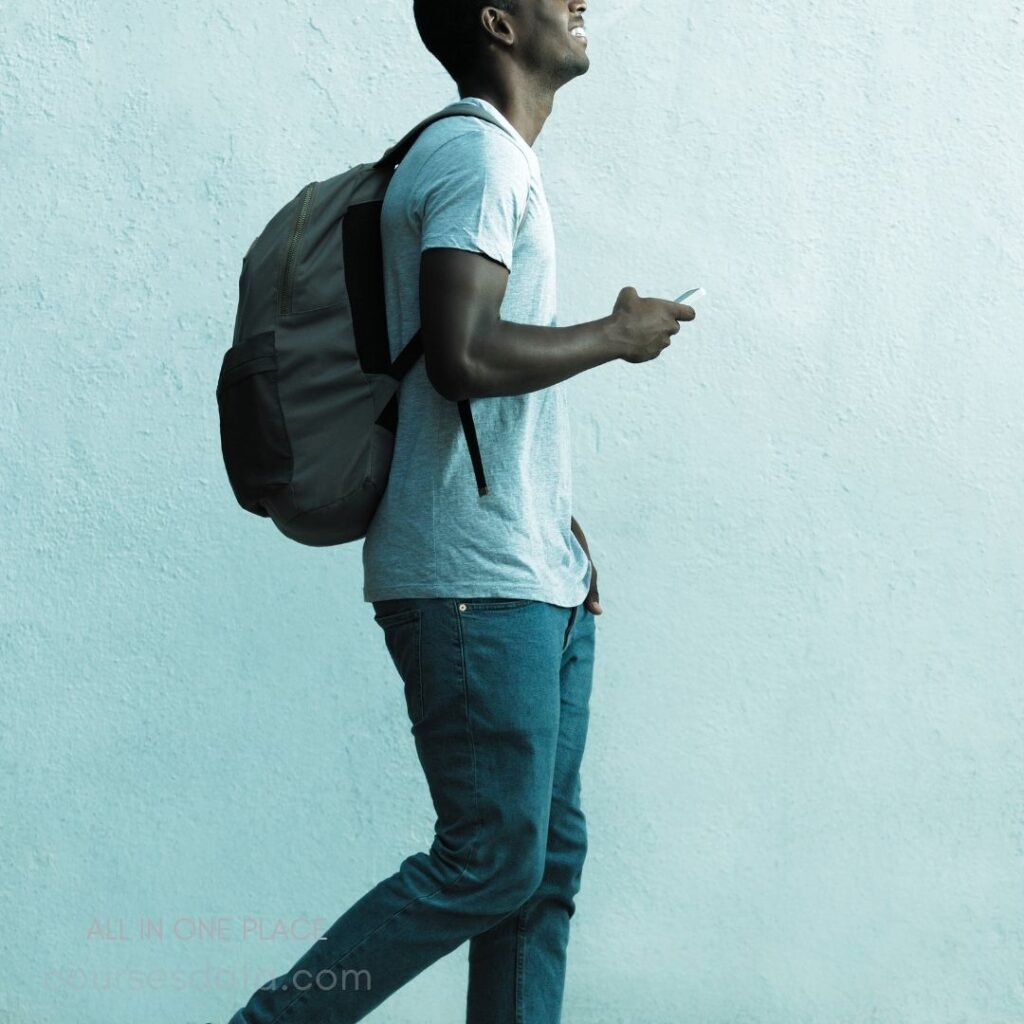 Man walking with backpack, smiling.