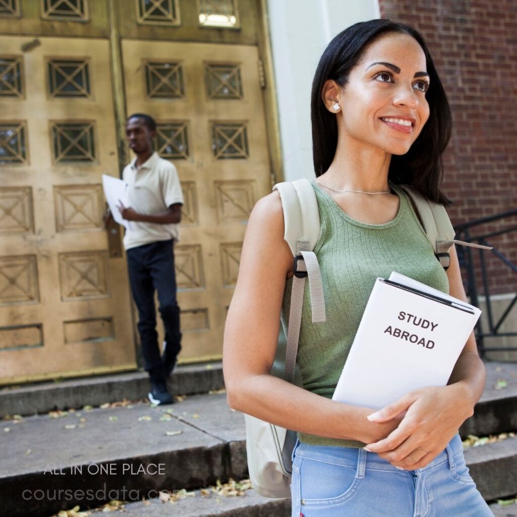 Smiling student holding study abroad booklet.