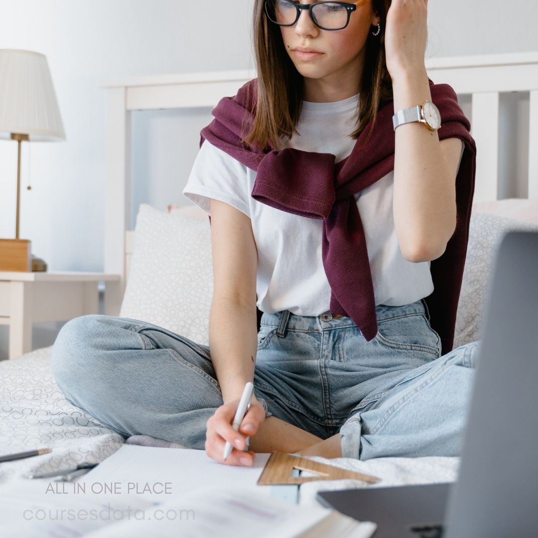 Student studying on bed.