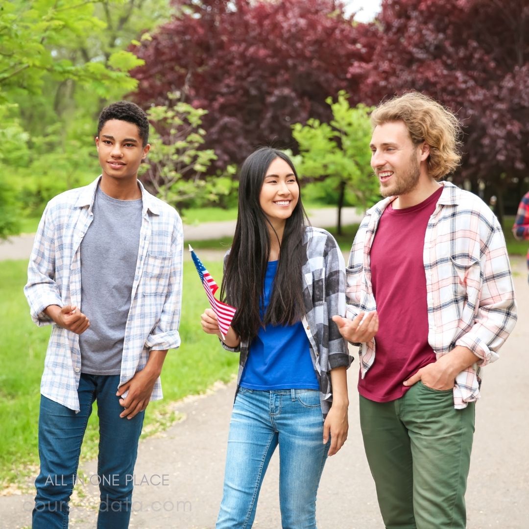 Three friends walking outdoors, smiling.