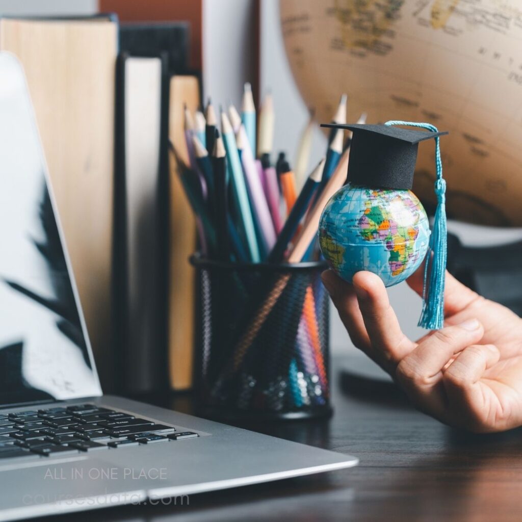 Globe with graduation cap, desk.