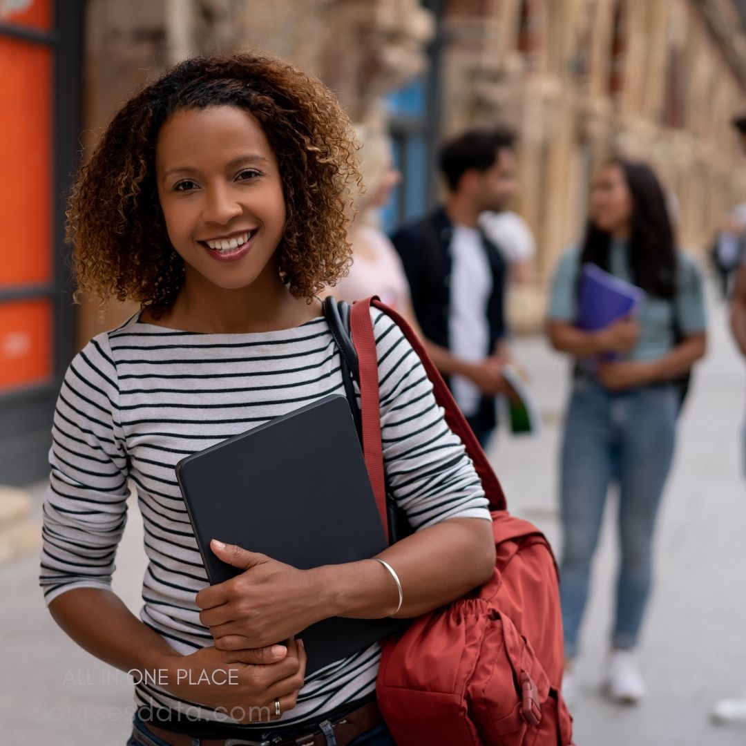 Smiling woman with laptop outdoors.