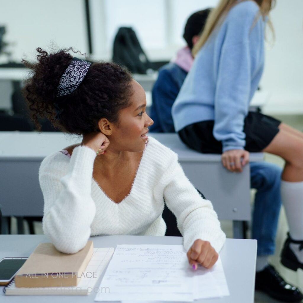 Student with curly hair smiling.