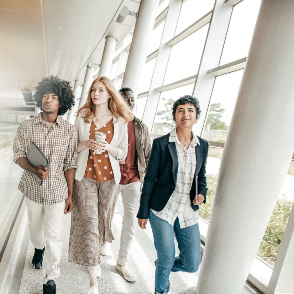 Diverse group walking indoors confidently.