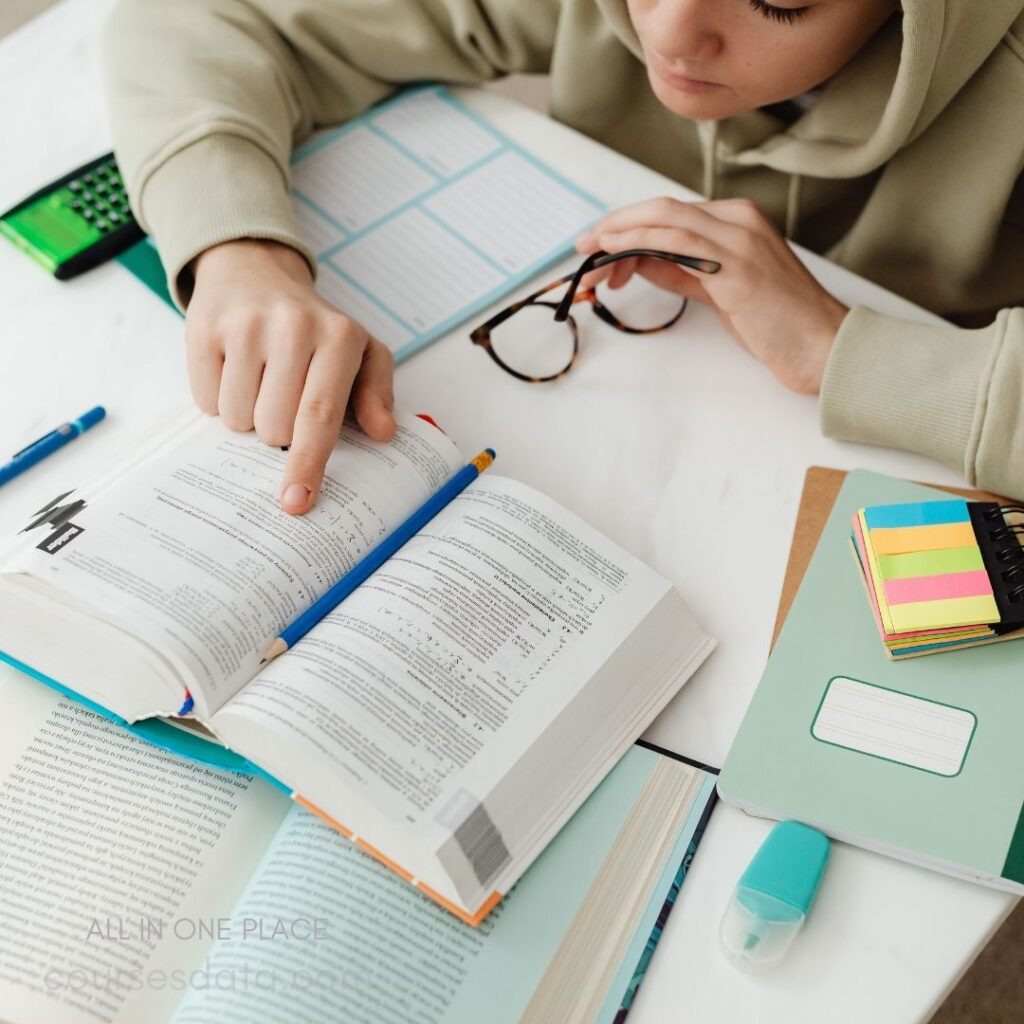 Student studying with open textbooks.