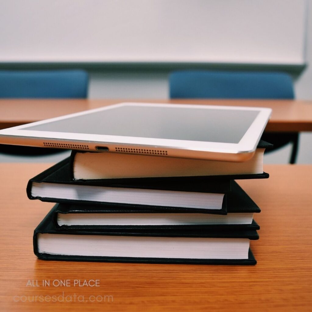 Tablet atop stacked notebooks.