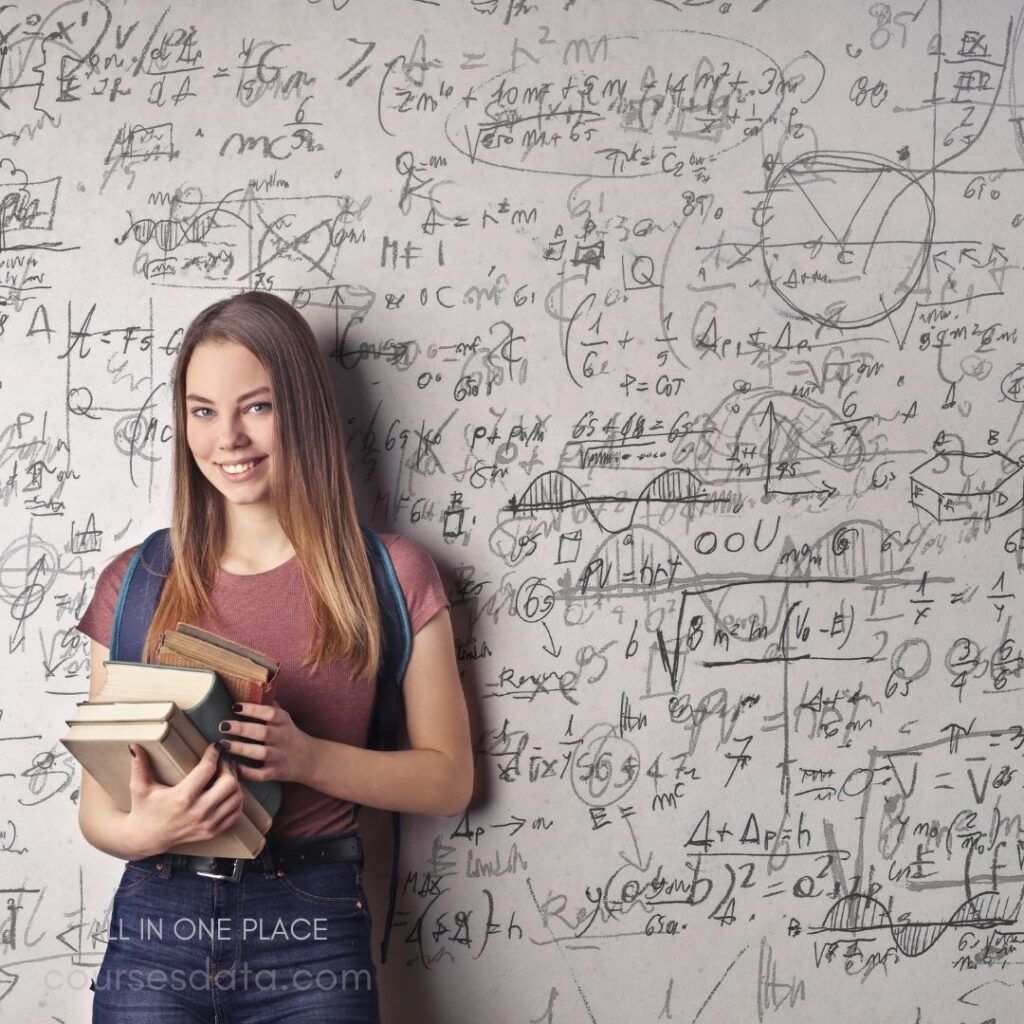 Smiling student holding books, equations.