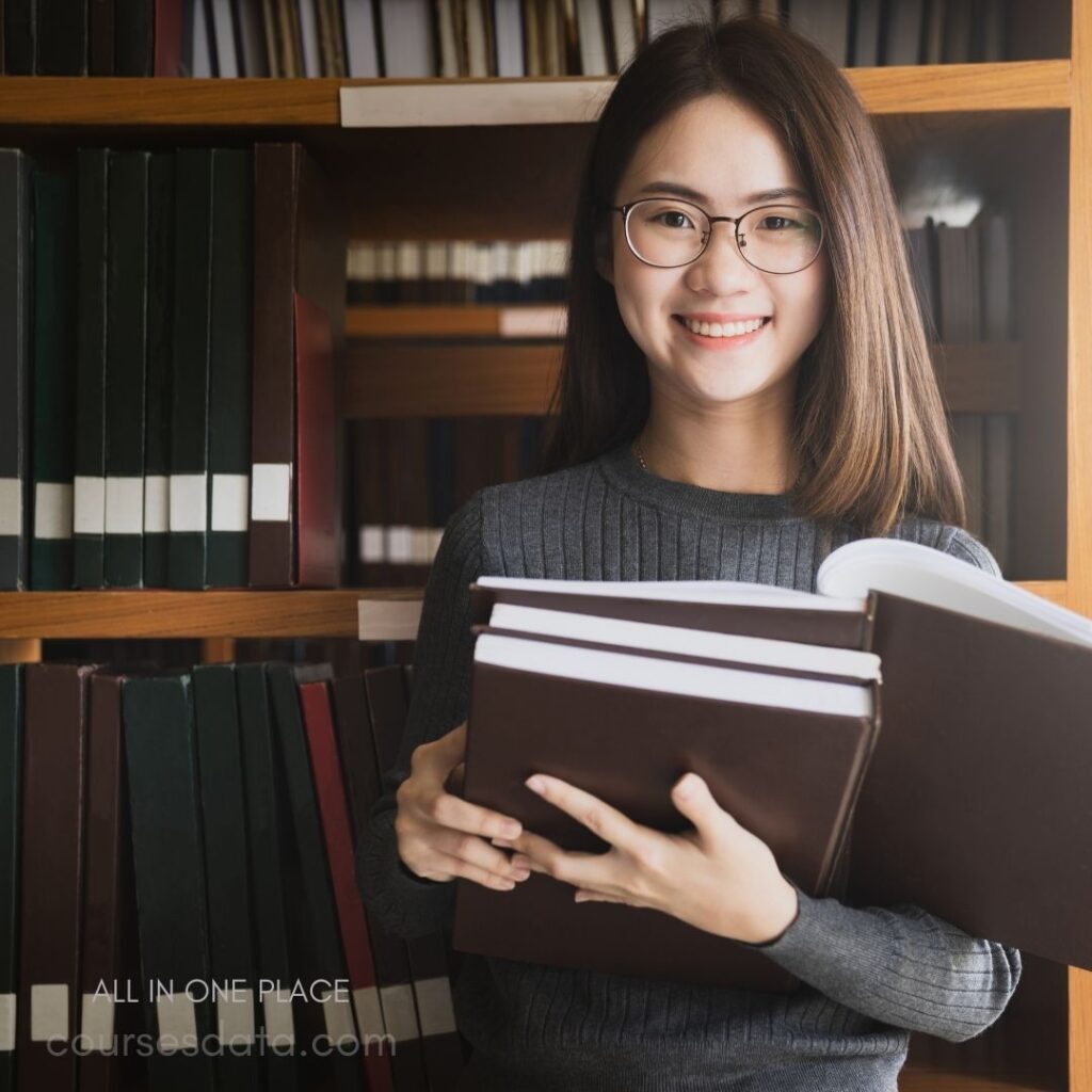 Smiling woman holds books.