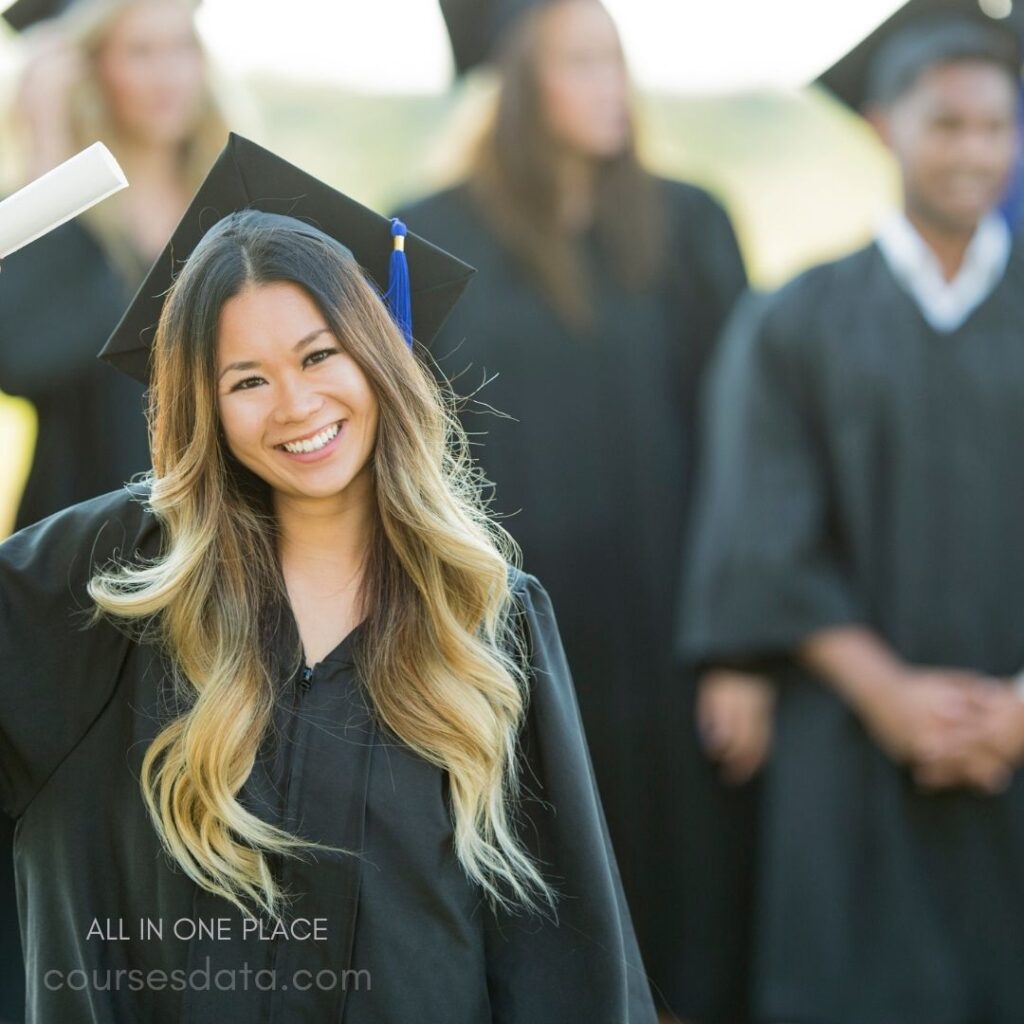 Smiling graduate holds diploma.