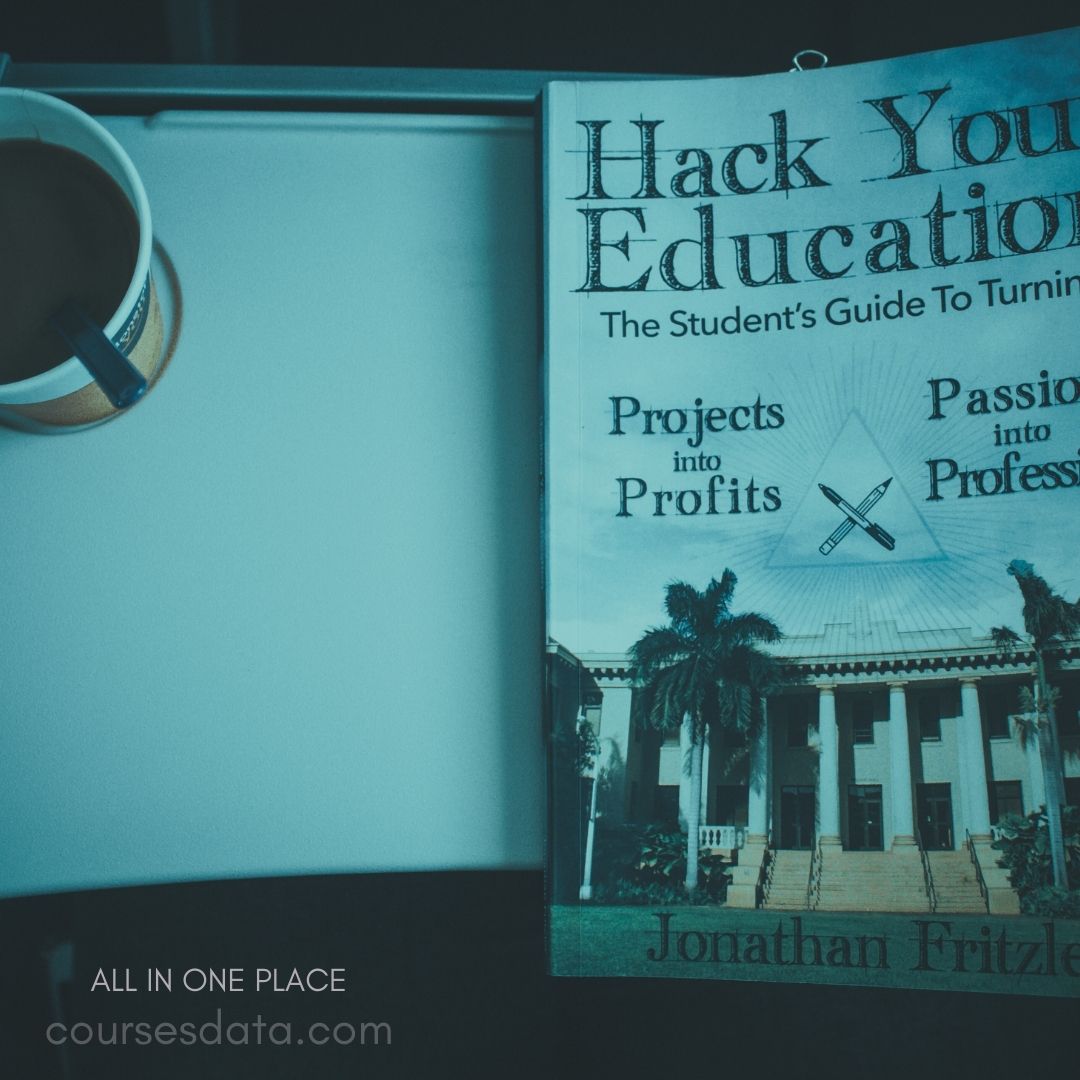 Coffee cup beside education book.