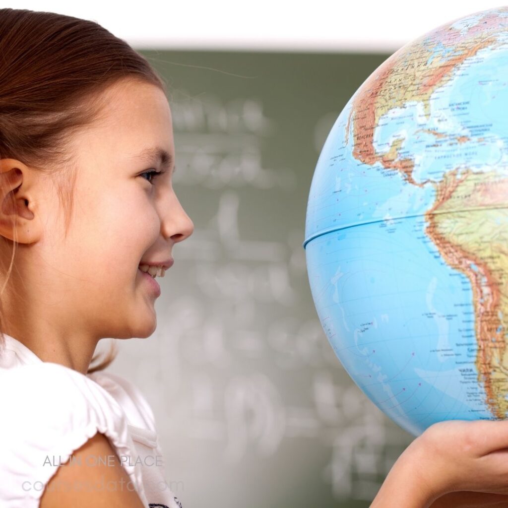 Girl holding a globe, smiling.