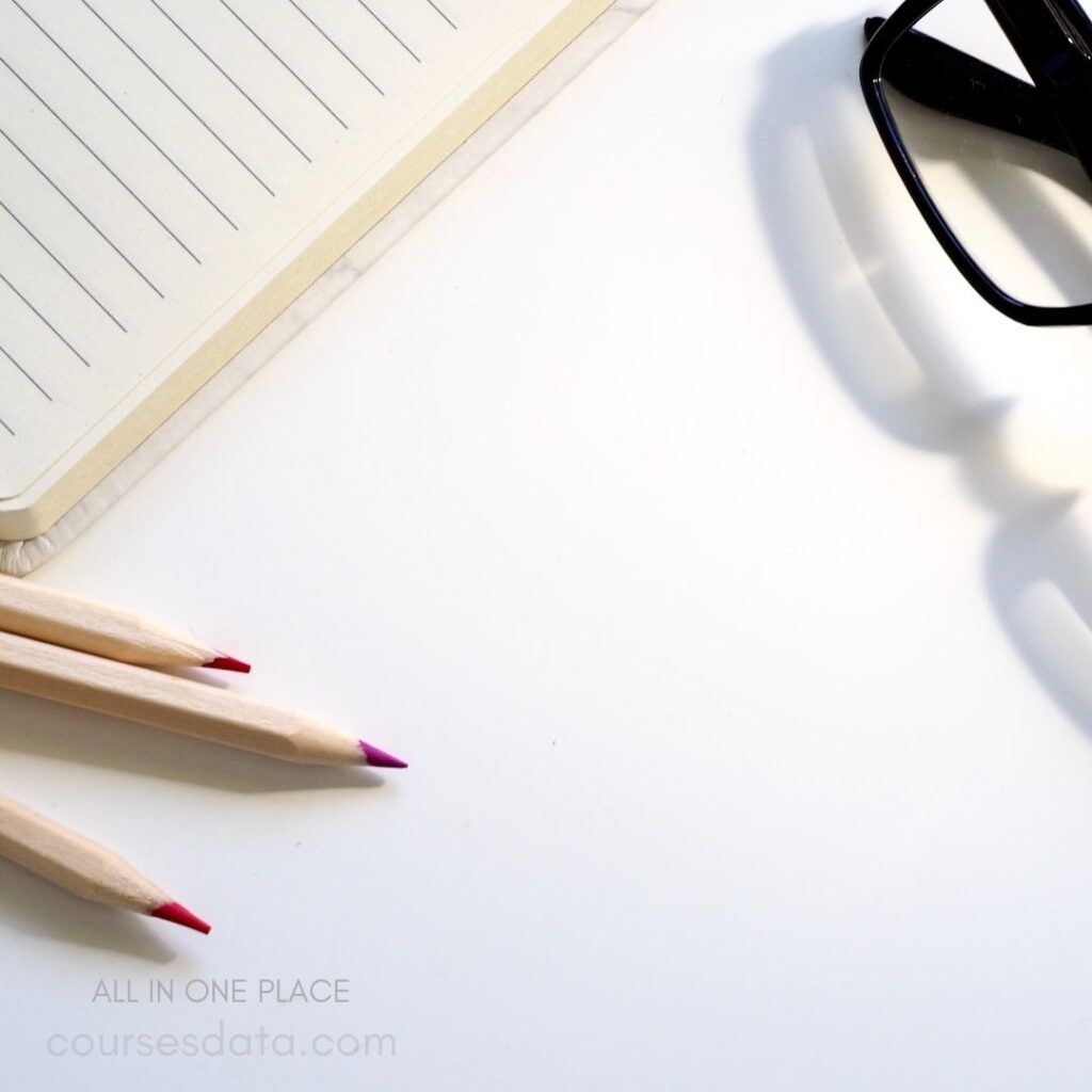 Colorful pencils, notebook, glasses.