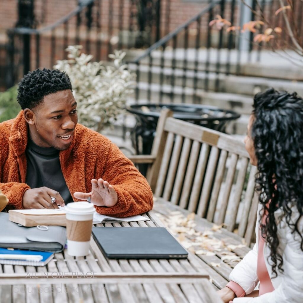 Friends discussing at outdoor table.