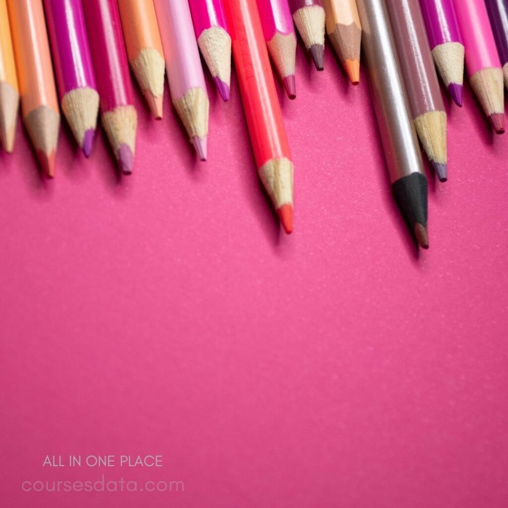 Colorful pencils on pink background.