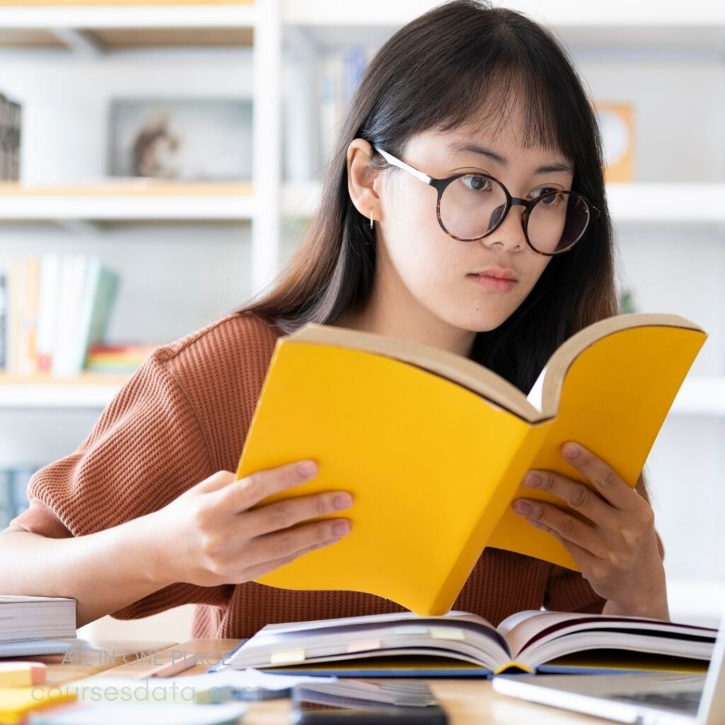 Young woman reading yellow book.