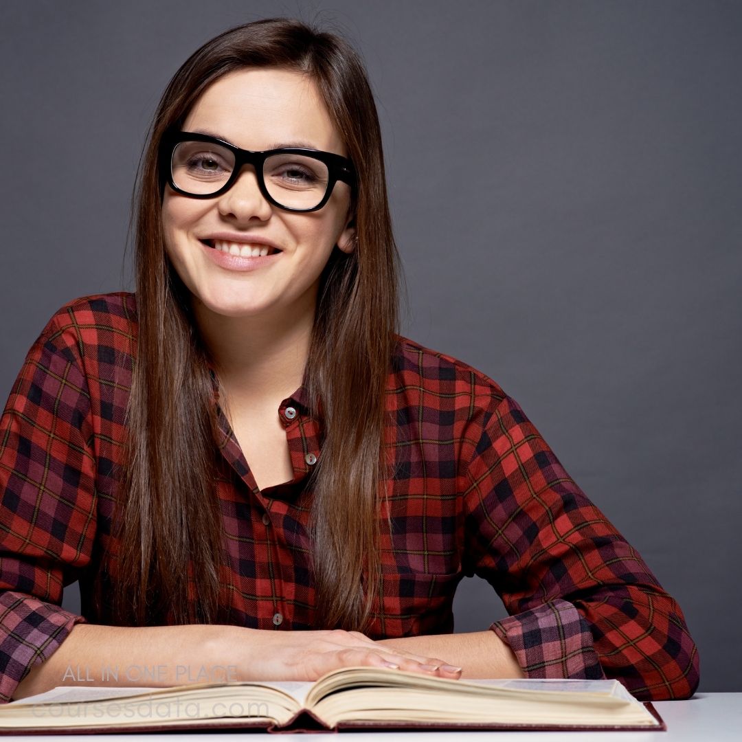 Smiling woman in glasses, plaid shirt.
