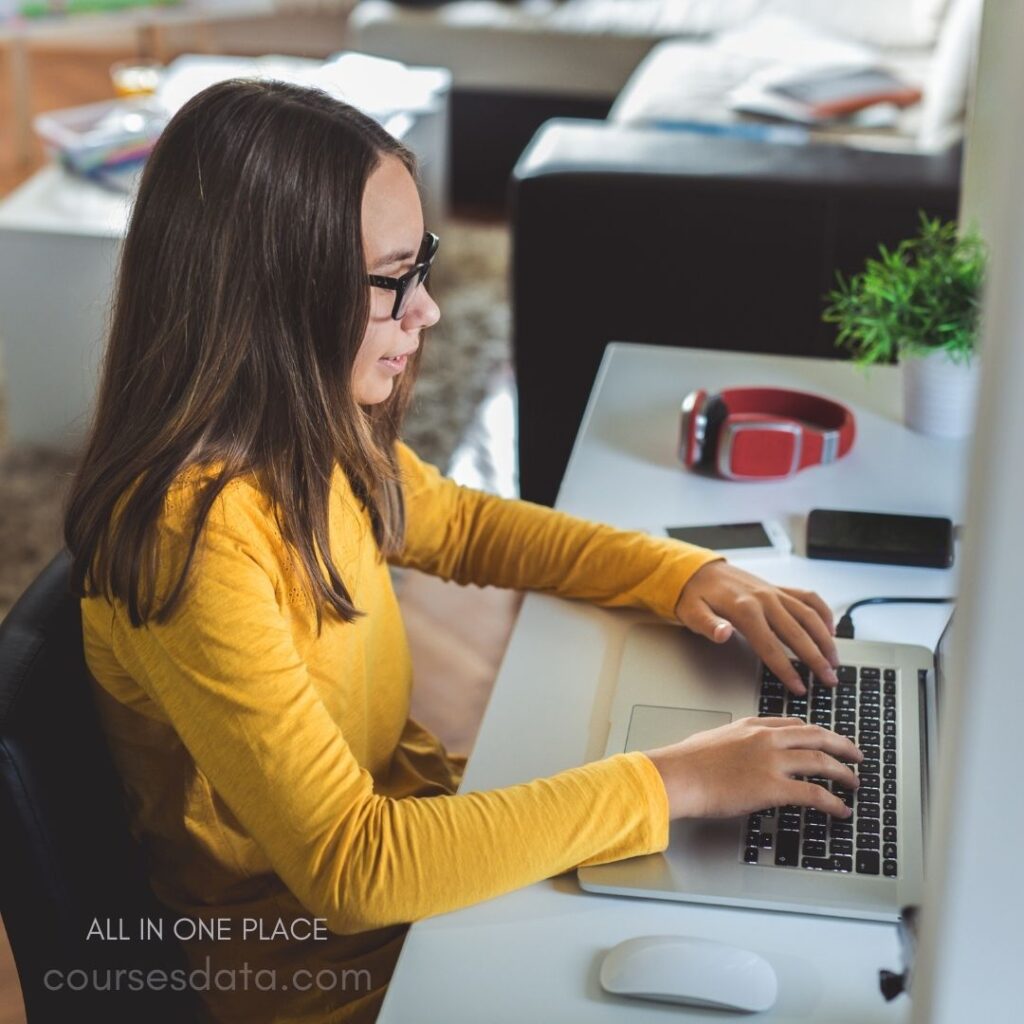 Girl using laptop at desk.