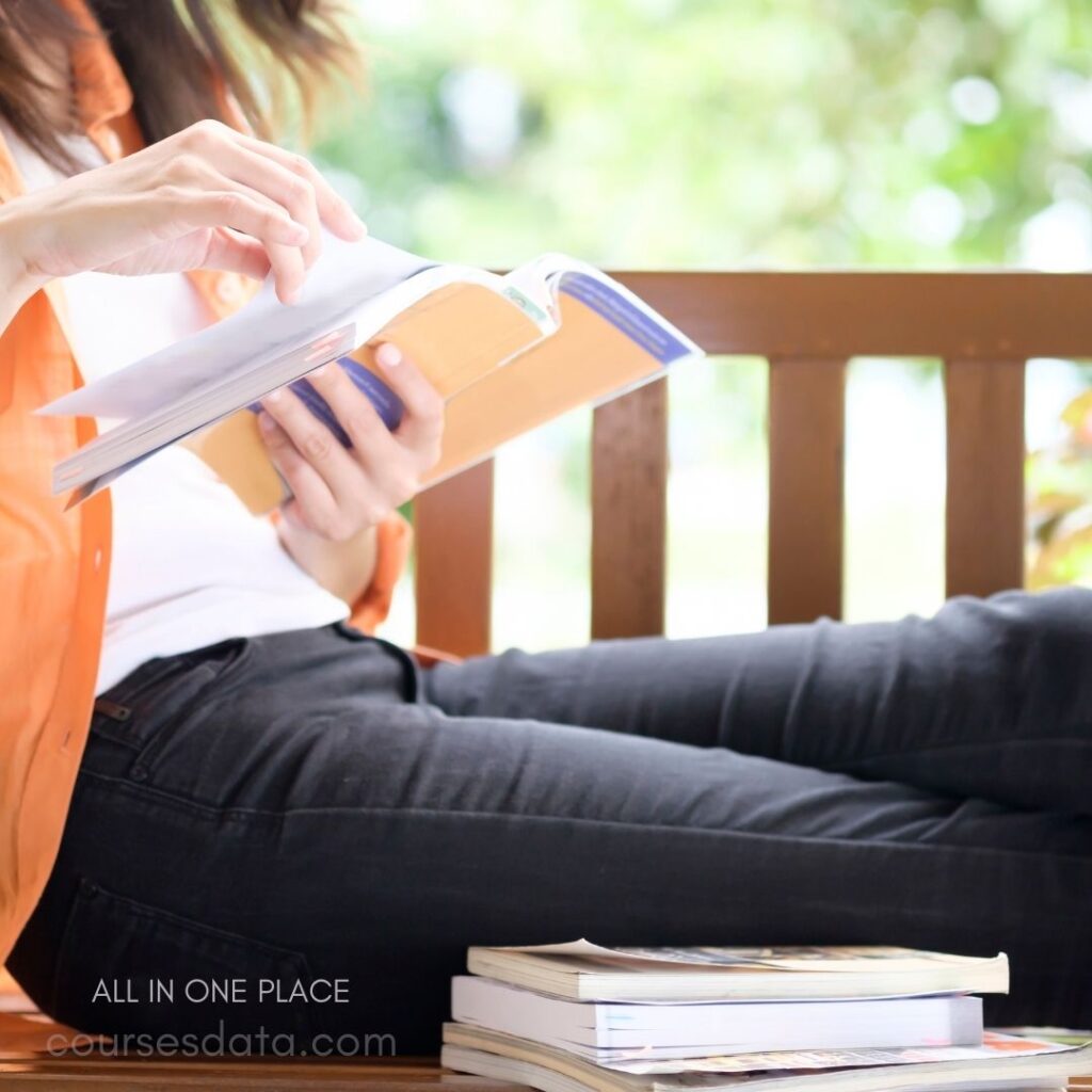 Person reading book outdoors.