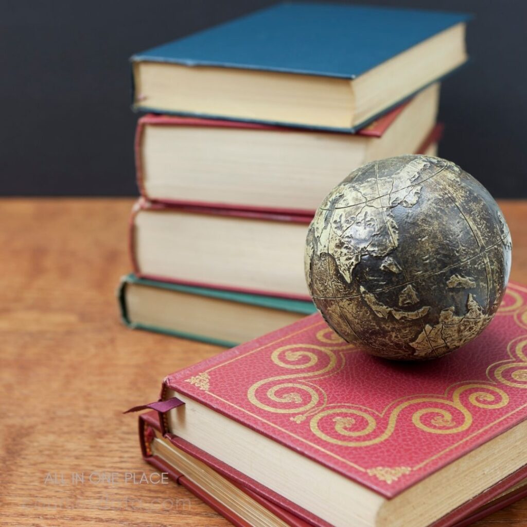 Books stacked with decorative globe.