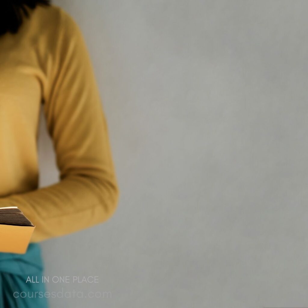 Person holding a book, yellow shirt.