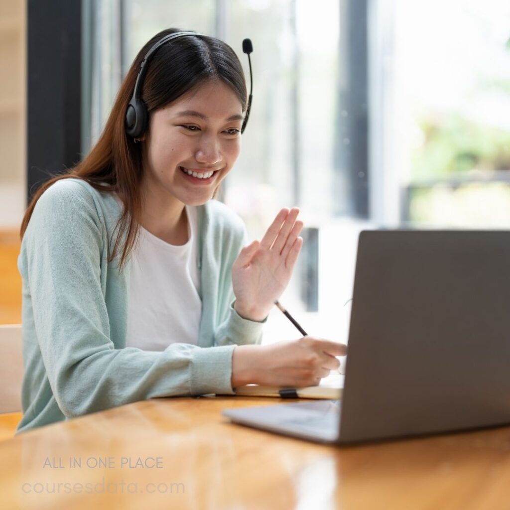 Smiling woman video calling laptop.