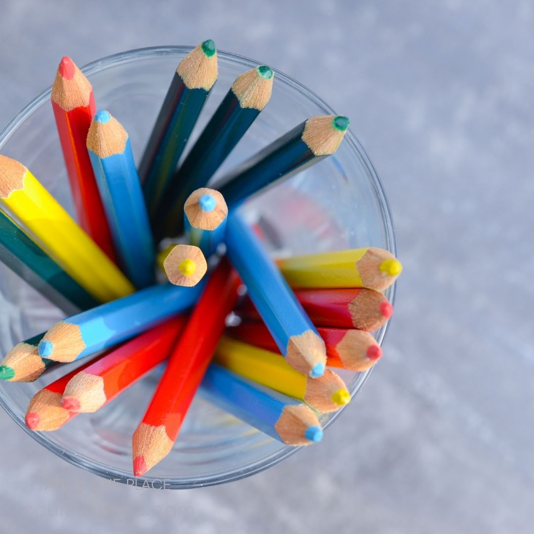 Colorful pencils in glass container.