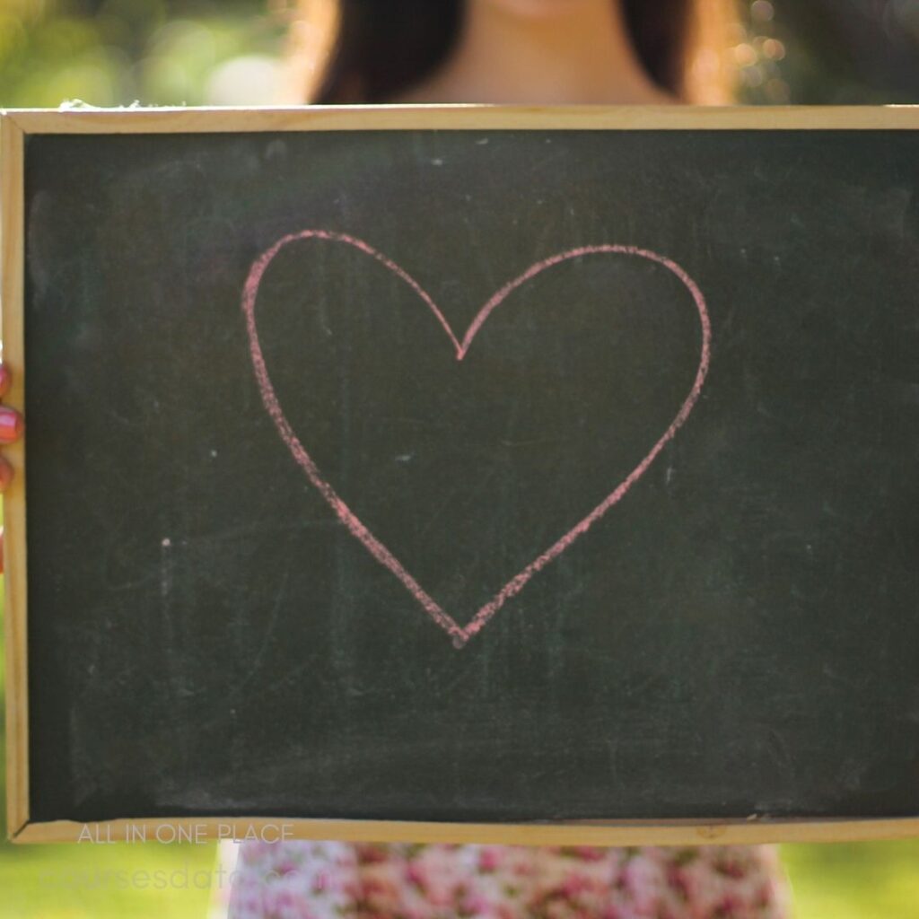 Chalkboard heart held outdoors.