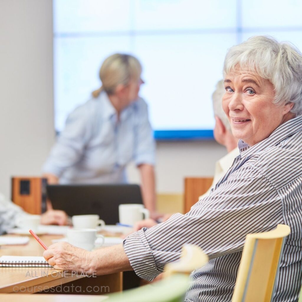 Elderly woman smiling in meeting.