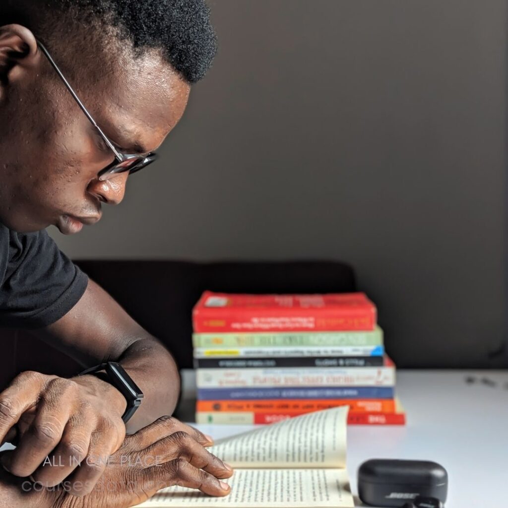 Man reading book, surrounded by books.