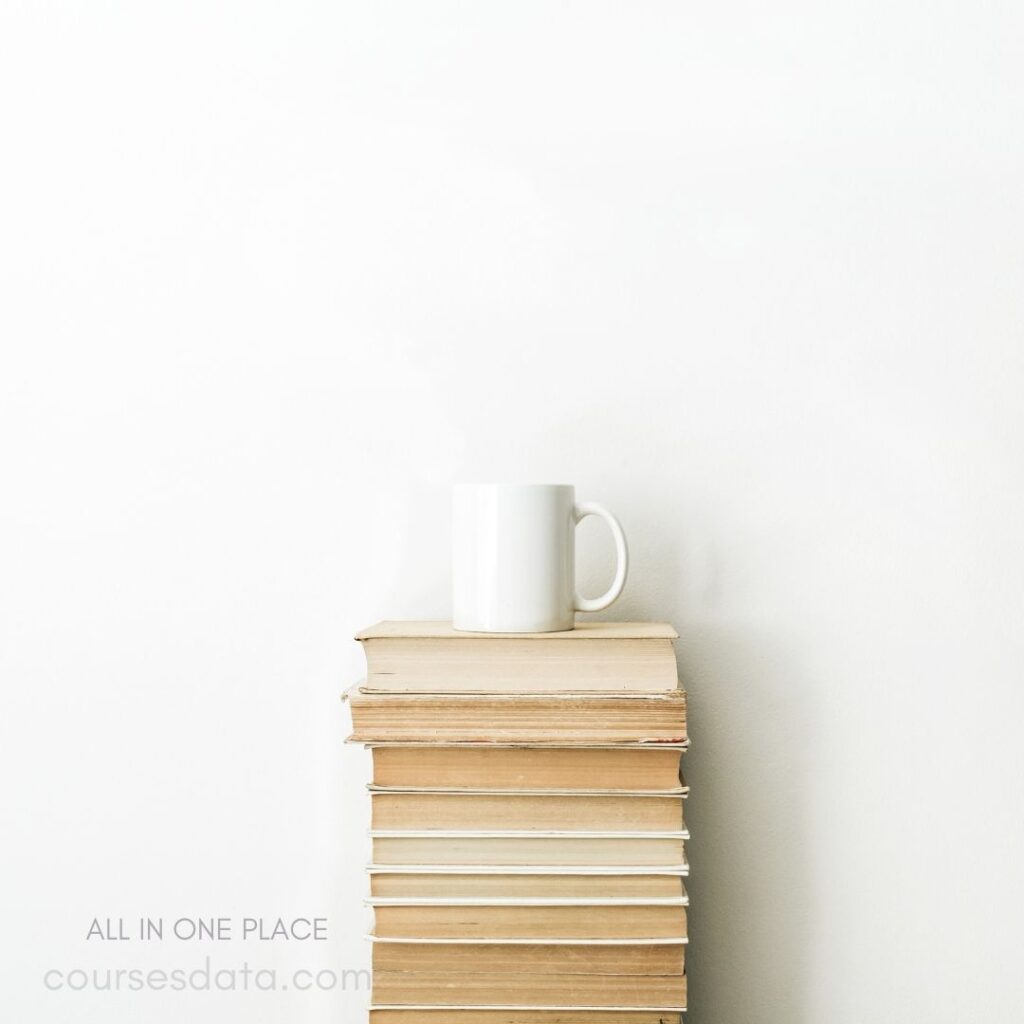 Books stacked with white mug.