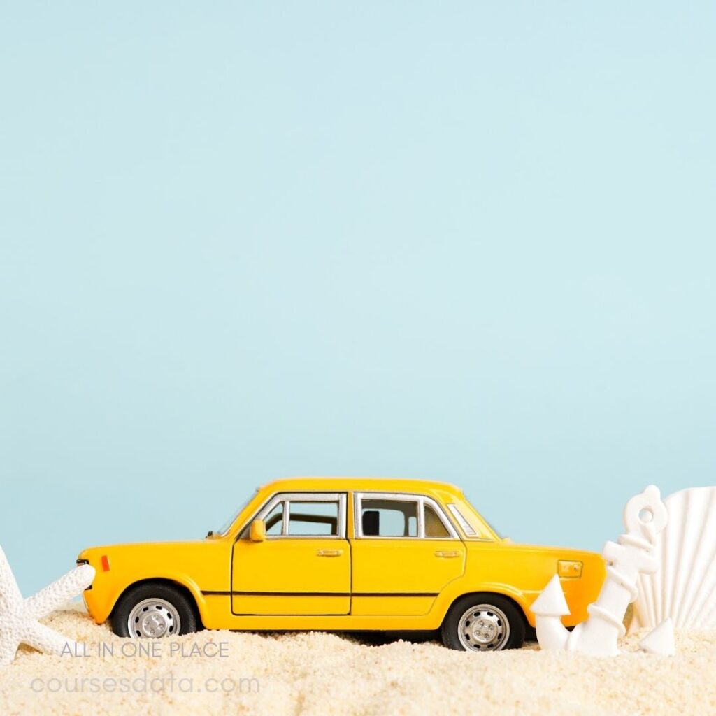 Yellow toy car on sand.