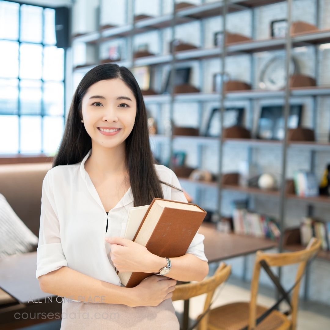 Smiling woman holding books.