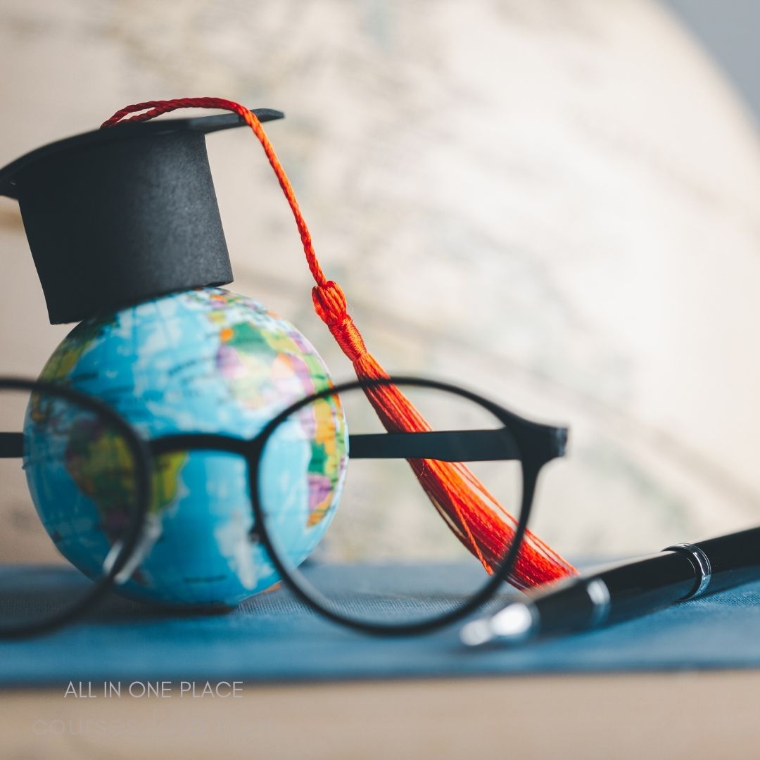 Globe with graduation cap and glasses.