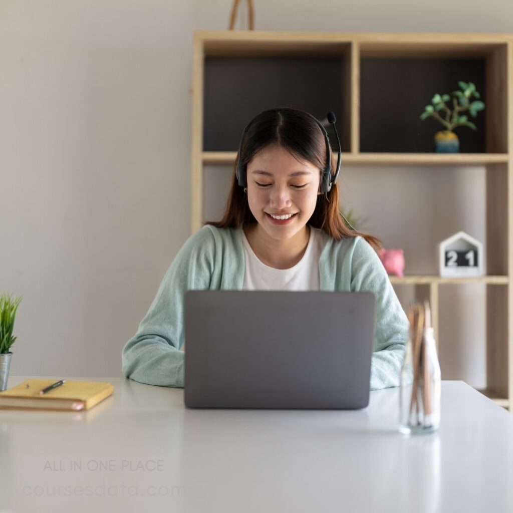 Smiling woman using laptop headset.