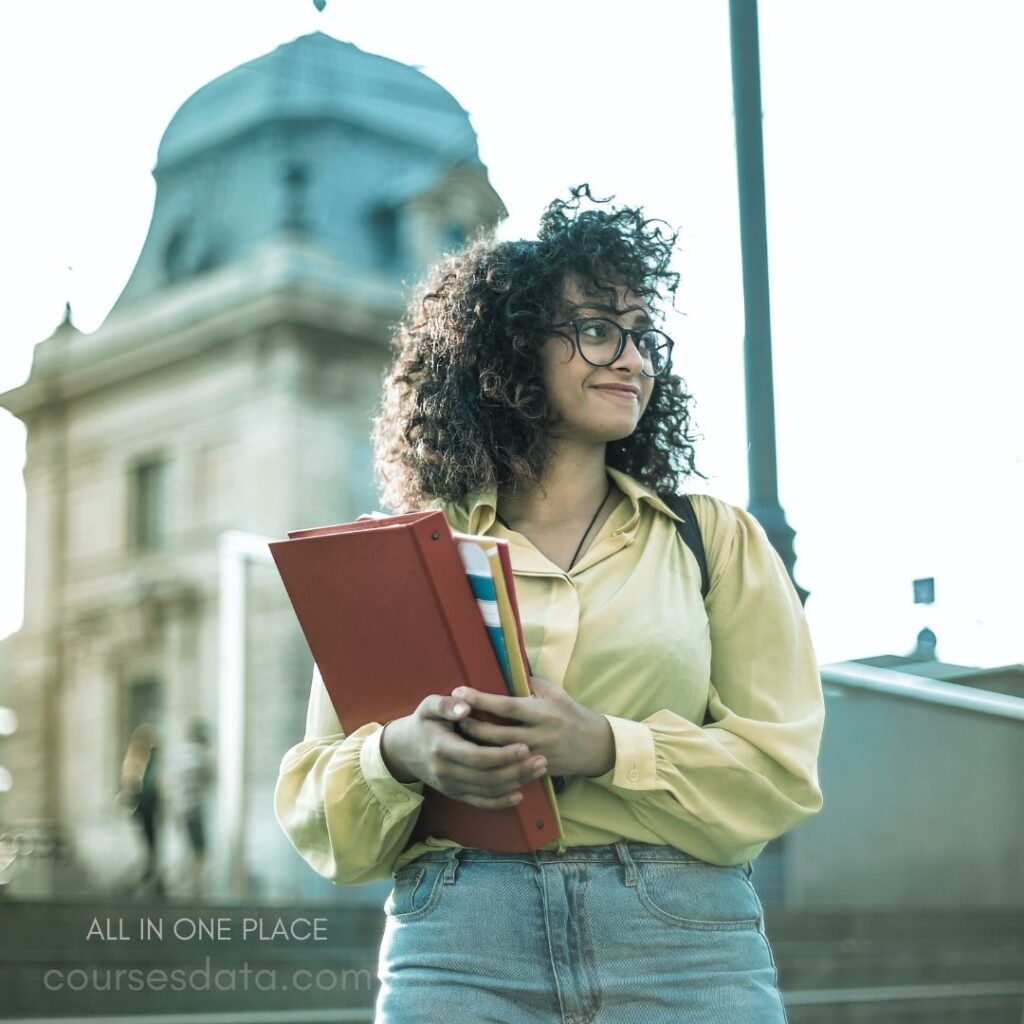 Smiling woman holding folders outdoors.