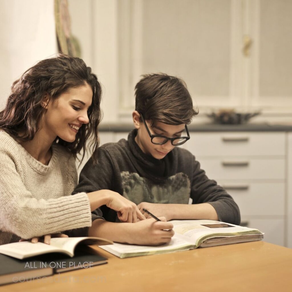 Student studying with attentive mentor.