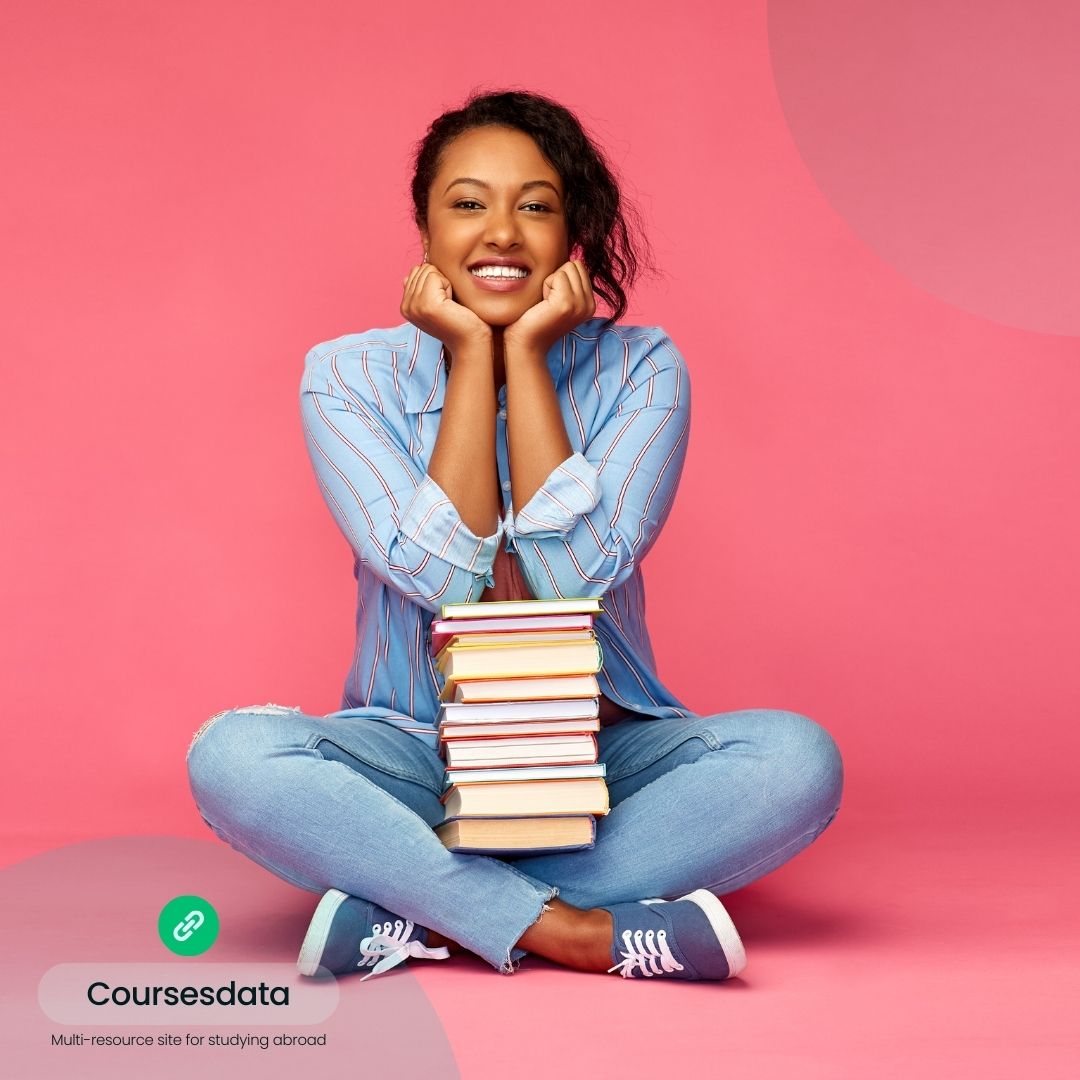 Smiling woman with stacked books.
