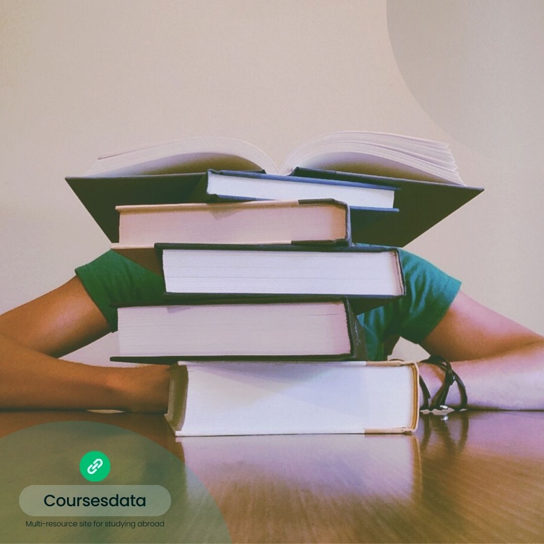Person hiding behind stacked books.