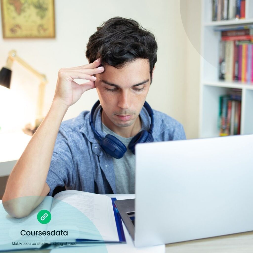 Stressed student studying at laptop.