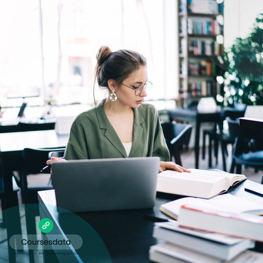 Woman studying with laptop and books.